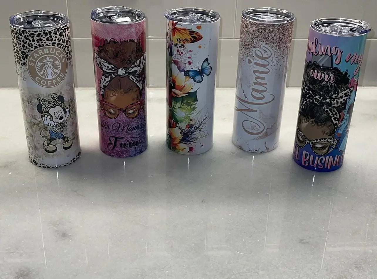 Five MY$TOAR luxury print tumblers with unique designs on a marble surface
