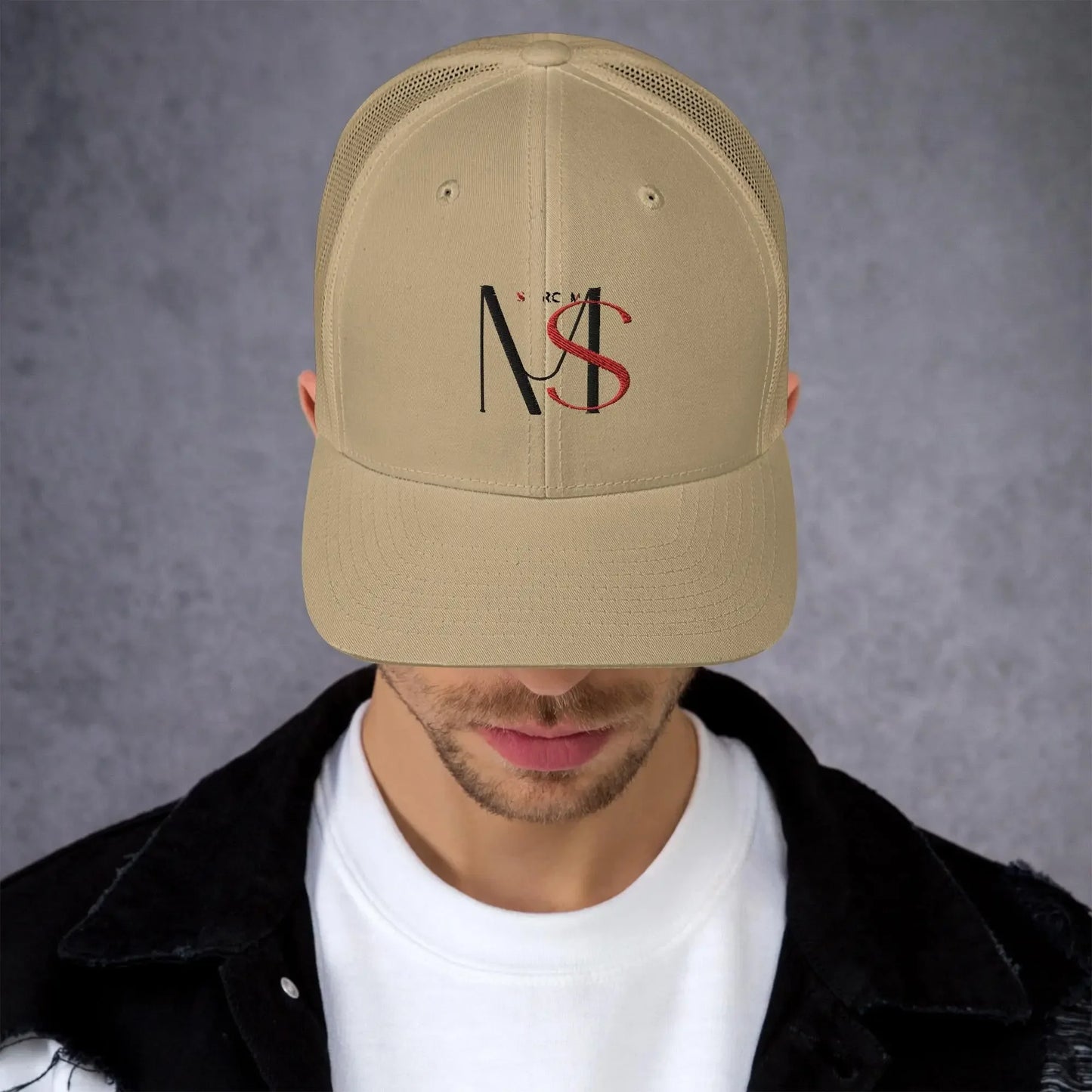 Khaki retro trucker hat with MY$TOAR NS logo, worn by man, luxury streetwear style