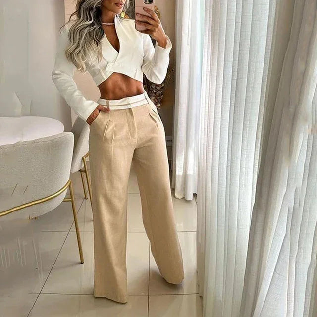Woman wearing luxury beige wide-leg pants and white cropped blazer in modern room, MY$TOAR fashion